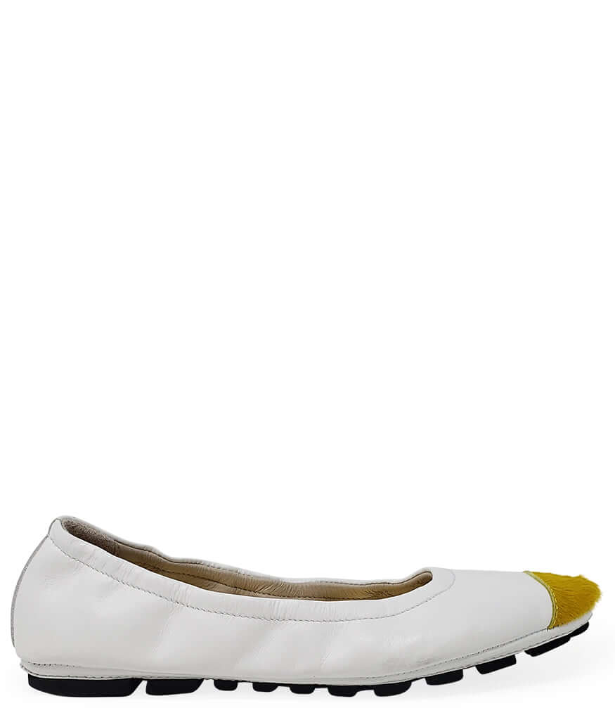 A pair of white leather ballet flats with a vibrant yellow calf hair toe cap and a black driving-style sole.