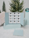 12 Days of EF Jewelry Advent Calendar box featuring gold charms and paperclip necklace in pastel blue and white packaging