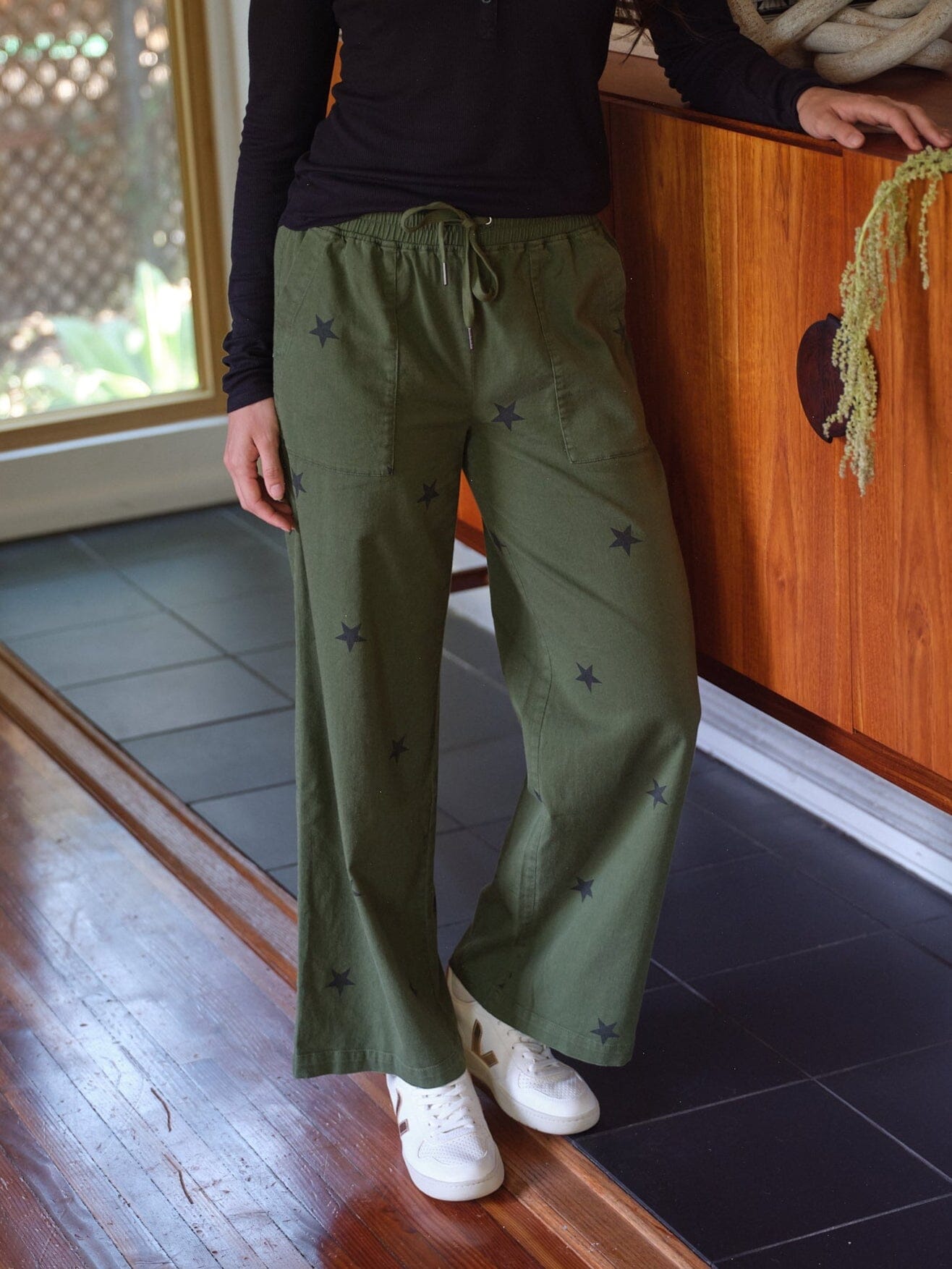 Cleo Wide Leg Pant in olive green with black star print, featuring a drawstring waist and patch pockets