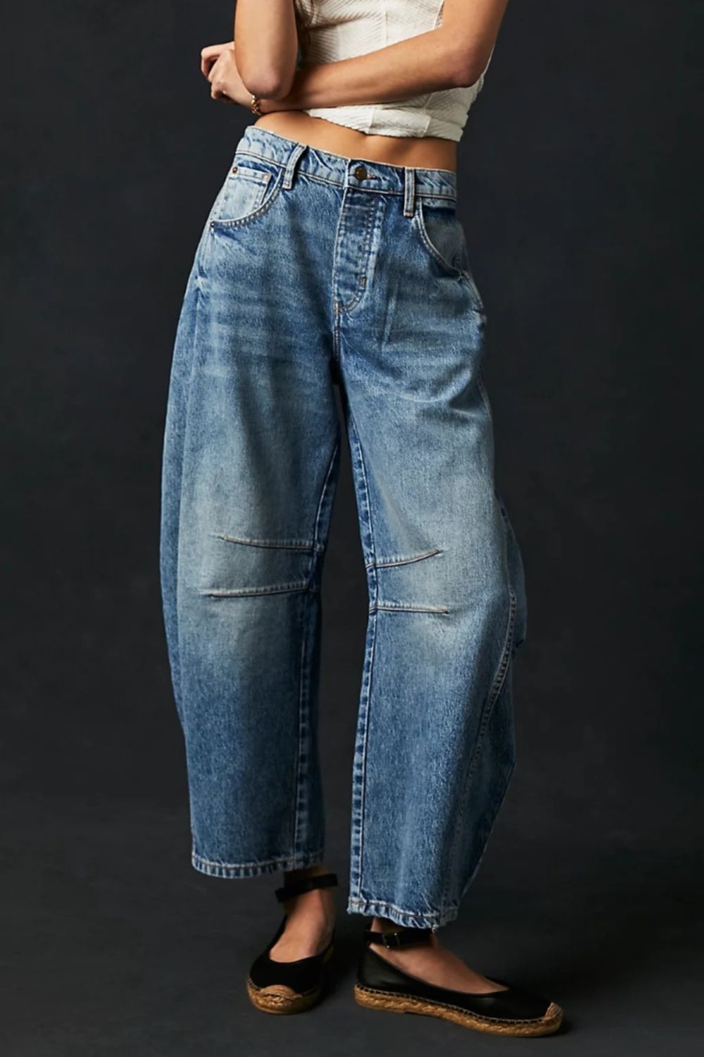 Model wearing blue wide leg denim jeans with button front and side pockets