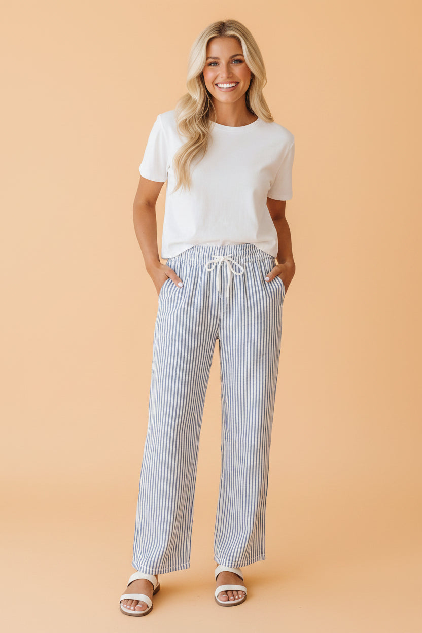 Woman wearing blue and white vertical striped high-rise wide leg linen pants with a drawstring waist