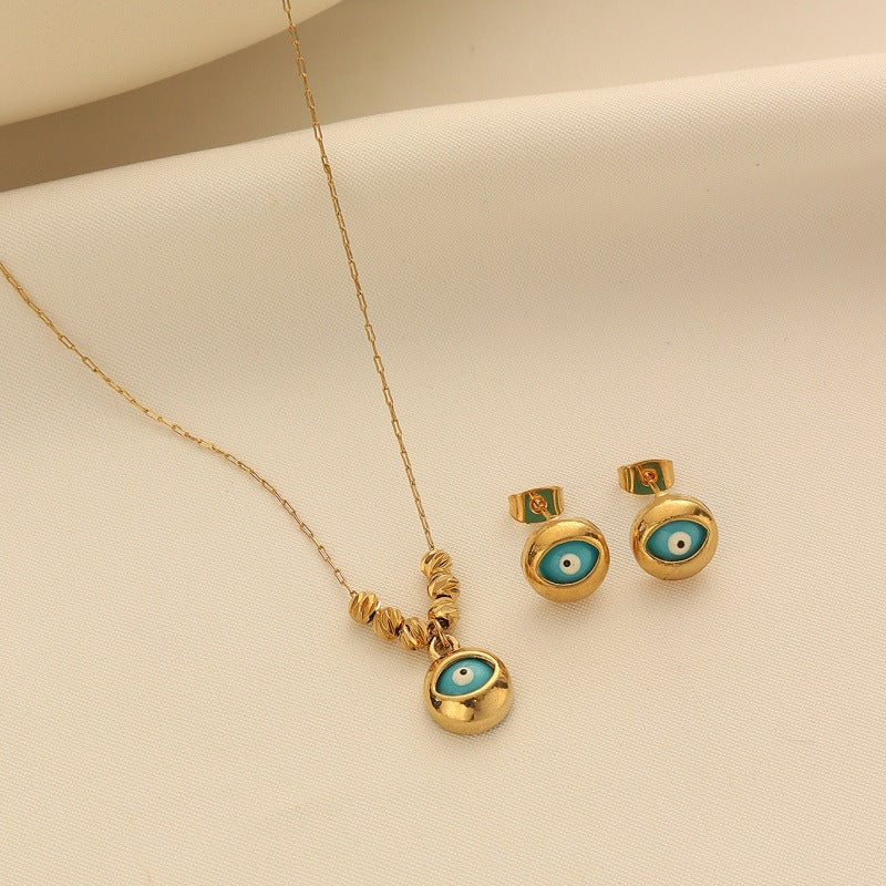 Gold-tone Turkish Evil Eye necklace and matching earrings set on a clean background.