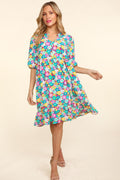 Woman wearing a romantic floral summer dress with bubble sleeves and ruffled details at a garden party.