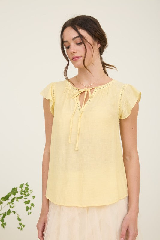 Front view of light yellow blouse with ladder lace trim and ruffle sleeves