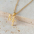 Close-up of a custom gold-tone interwoven letter necklace featuring elegant script initials.