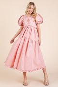 A feminine tiered babydoll midi dress with ruffle trim and puff sleeves.