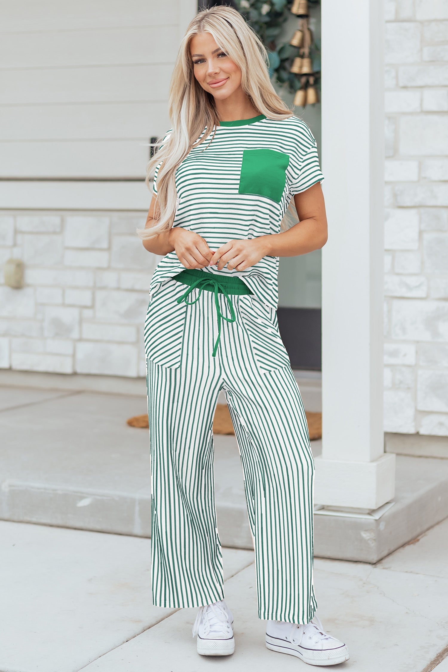 Woman wearing a kelly green and white striped short sleeve tee and matching relaxed fit pants set