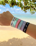 Collection of six adjustable WWJD faith bracelets in a variety of colors including pink, mint, blue, lavender, black, and white.
