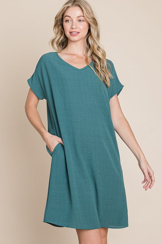 Woman wearing a comfortable V-neck short sleeve casual dress with functional side pockets