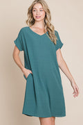Woman wearing a comfortable V-neck short sleeve casual dress with functional side pockets