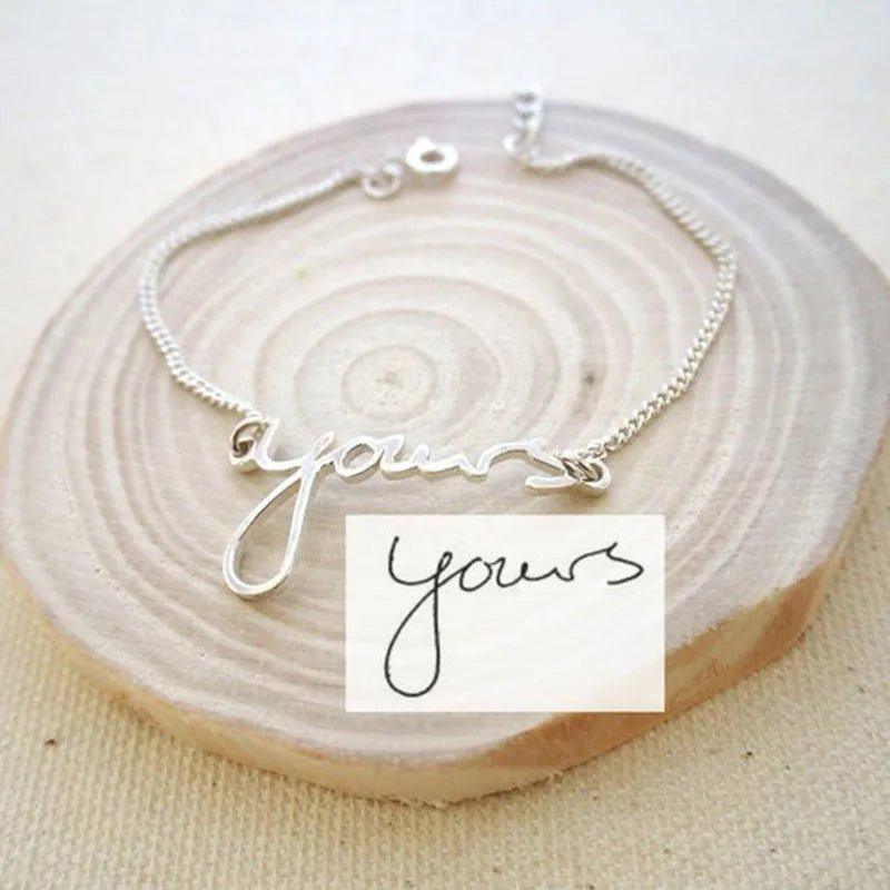 Custom name bracelet featuring an engraving of actual handwriting on a minimalist metal bar.