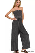 Woman wearing a strapless denim jumpsuit on a white background