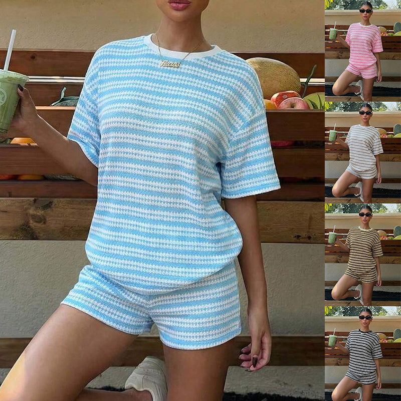A woman wearing a two-piece striped matching set with a short-sleeved t-shirt and shorts.