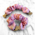 An Empress Pink floral patterned scrunchie with an easy-release buckle for Lunar New Year styling.