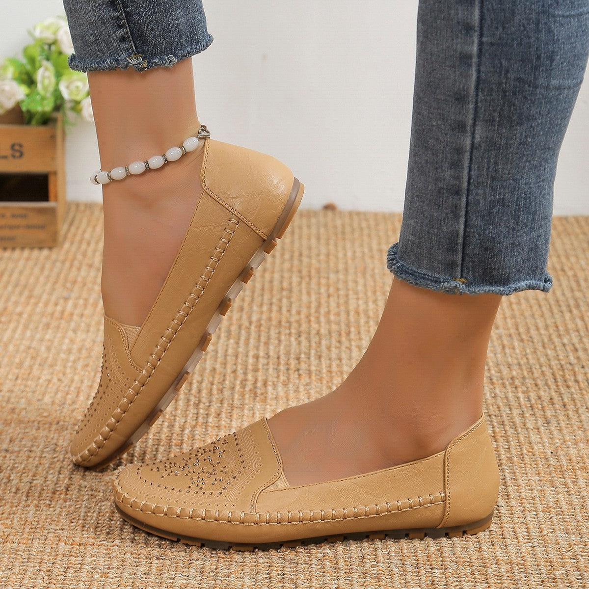 A pair of women's handmade Gommino driving shoes in solid beige worn with blue jeans.