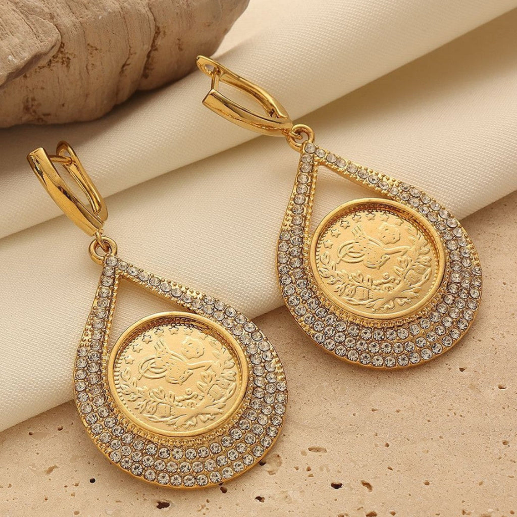 Vera Lux 18K gold-tone textured coin stud earrings with subtle crystal detailing on a white background.