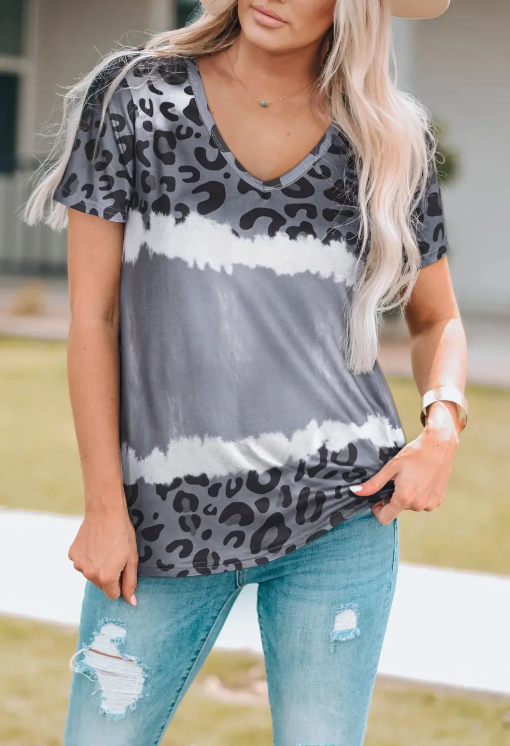 A woman wearing a comfortable short sleeve V-neck T-shirt with a bold leopard print pattern