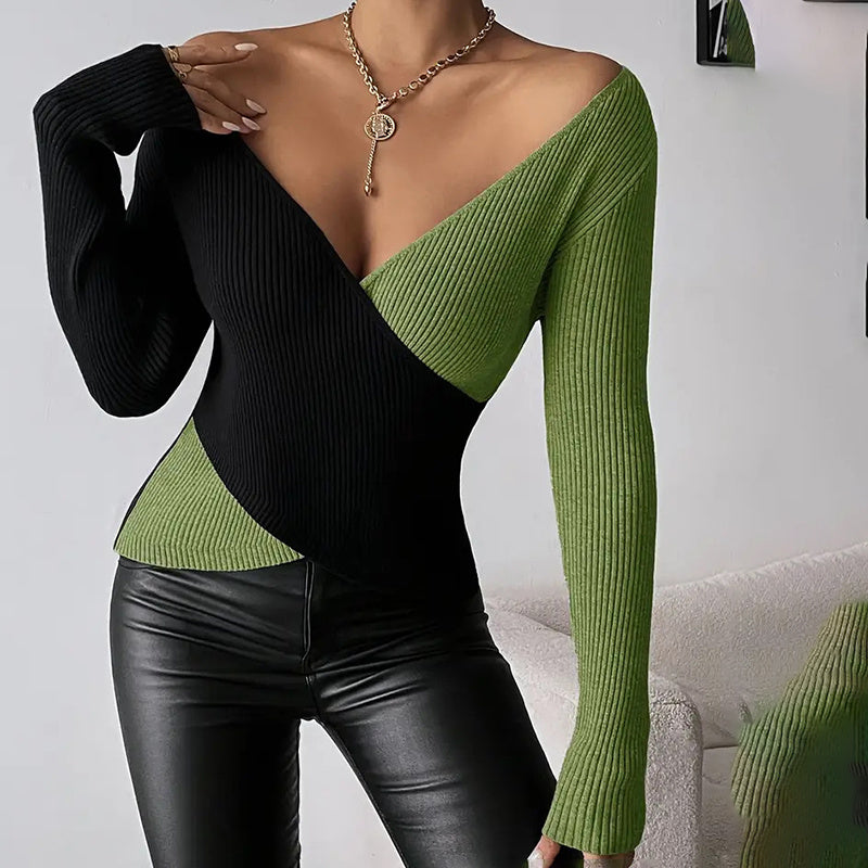 A woman wearing a black and green color block ribbed knit V-neck sweater with a cross-front detail.