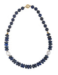 A 19-inch necklace featuring deep blue lapis lazuli beads, white freshwater Edison pearls, and small gold-tone hematite accents with a magnetic clasp.