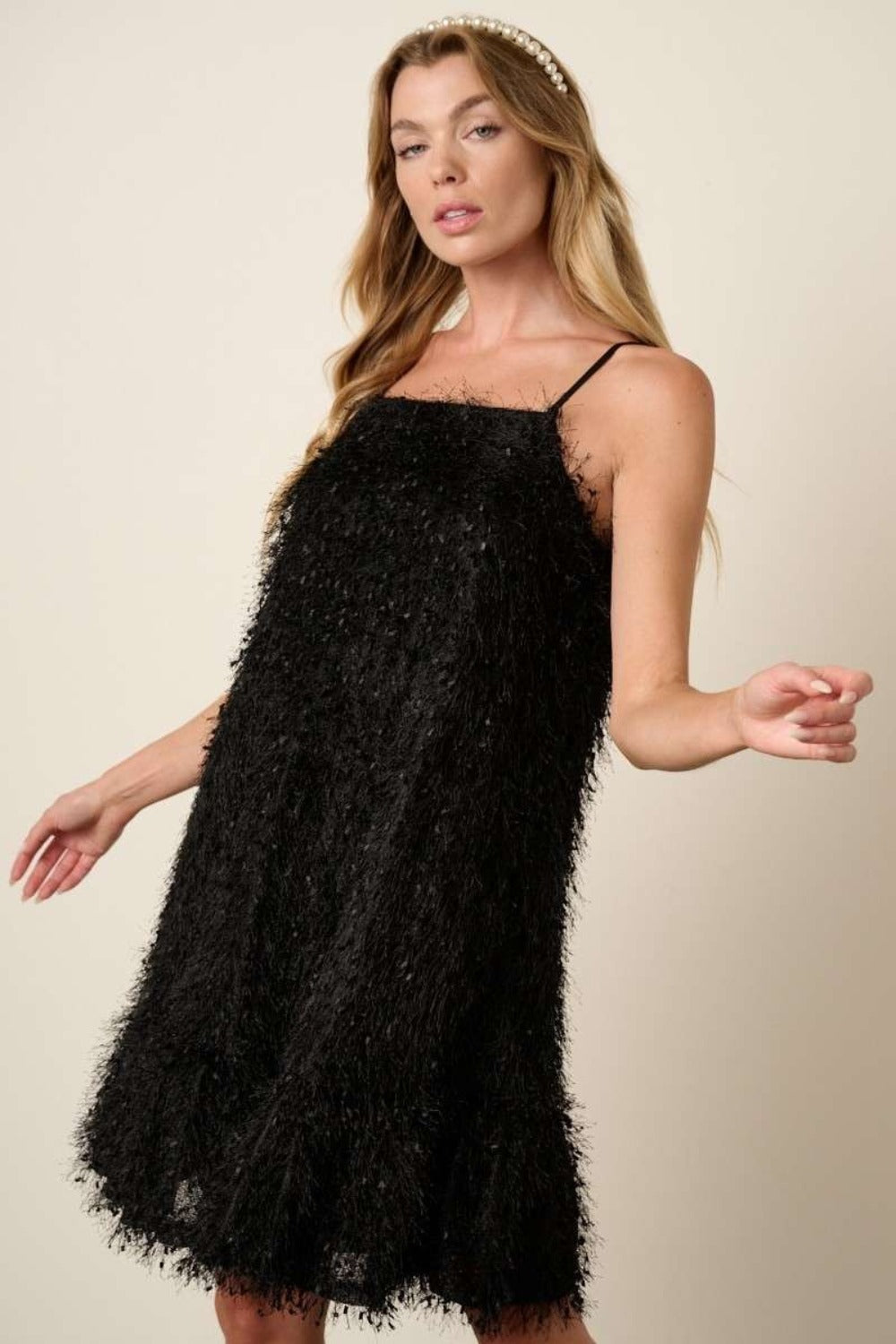Black cami mini dress featuring a playful feather ruffle hem