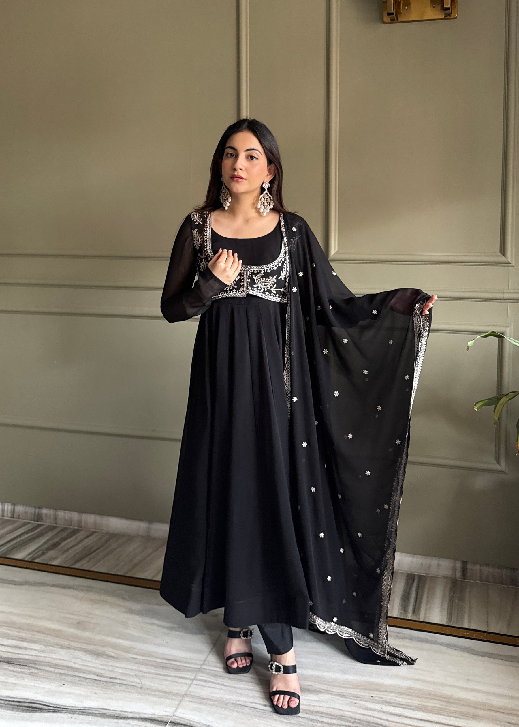 Model wearing a black 16-kali Anarkali gown with intricate silver fancy work on the yoke and a matching dupatta