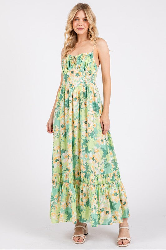Model wearing a floral print summer maxi cami dress with a ruffled hem and smocked back.