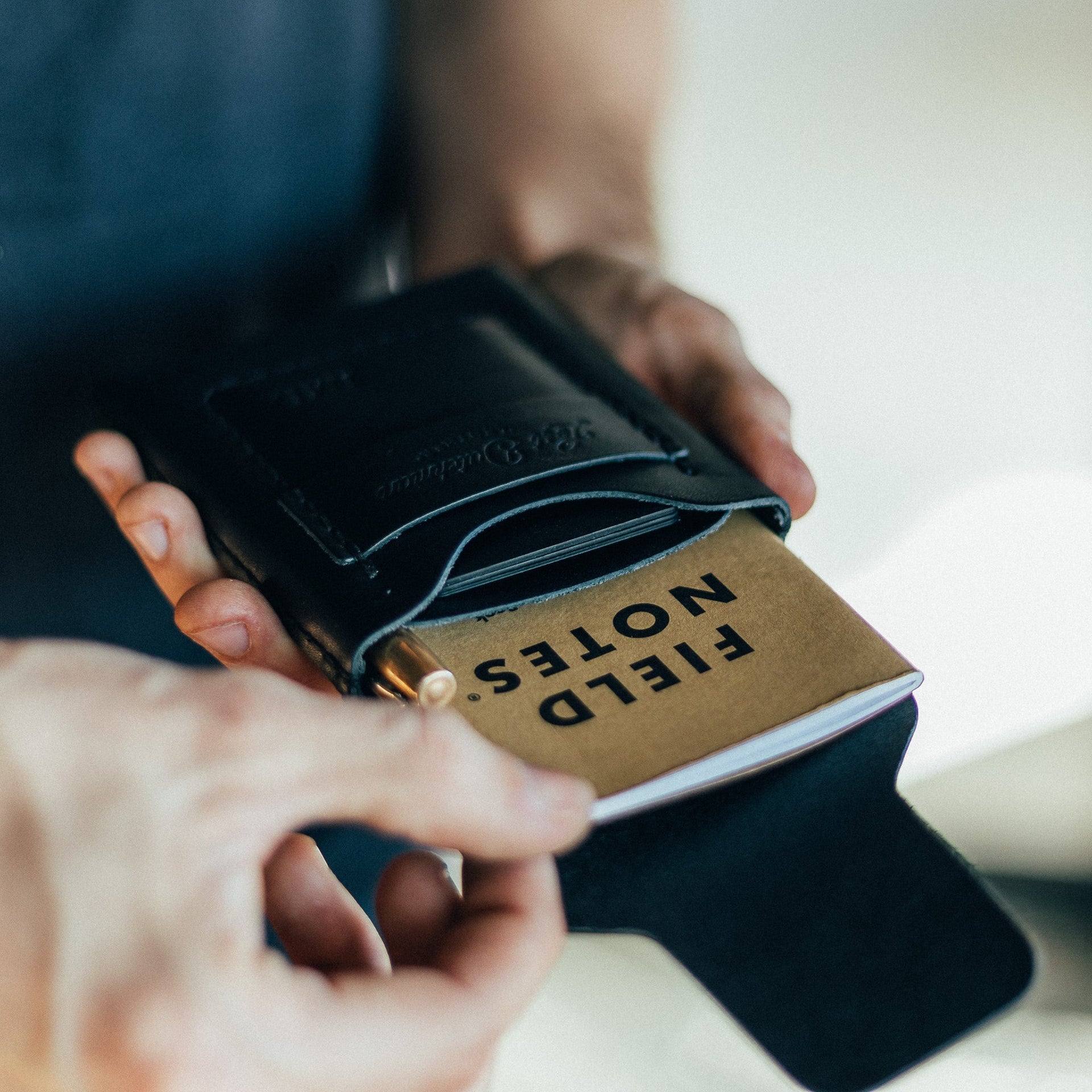 Black leather Huckleberry tall notebook wallet open to reveal pocket layout.