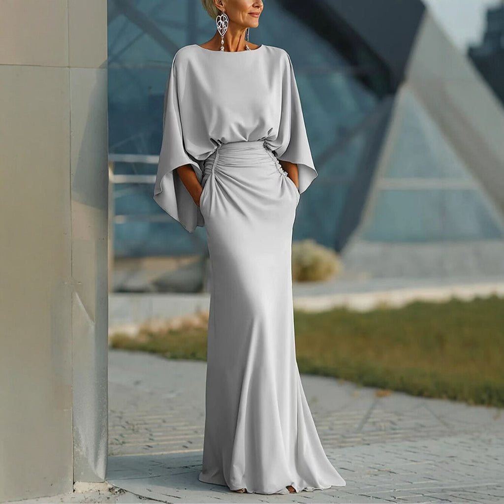 Elegant silver backless pleated mermaid gown with dramatic batwing sleeves.