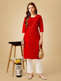 Women wearing a bright red embroidered cotton blend straight kurta with matching pants