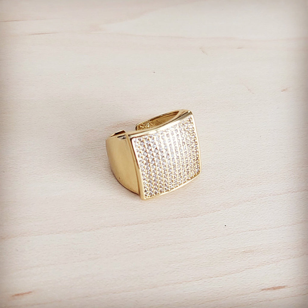 Gold-tone square ring with pave clear crystal stones and adjustable open back band on a light wooden background