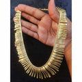 A traditional gold-tone designer necklace with intricate detailing, perfect for wedding outfits.