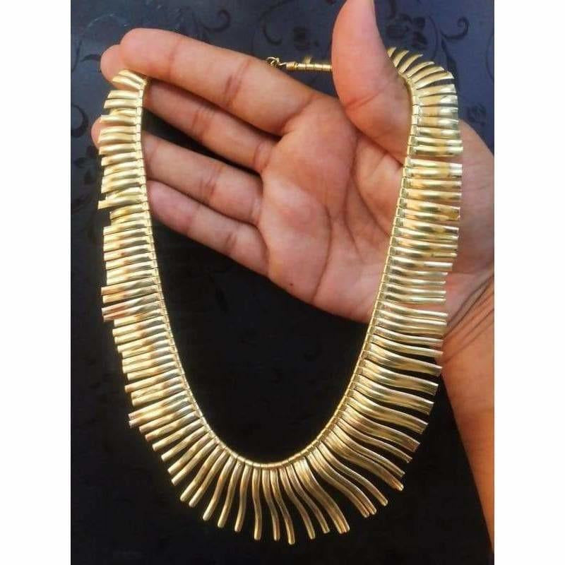 A traditional gold-tone designer necklace with intricate detailing, perfect for wedding outfits.