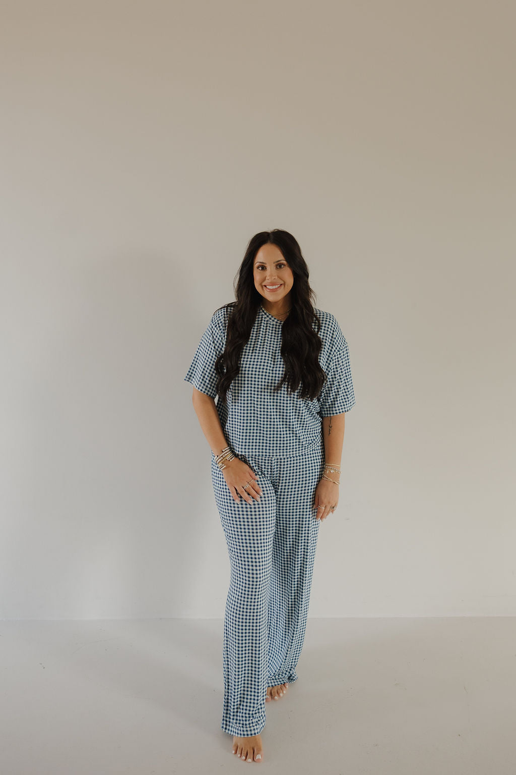 Woman wearing a blue and white gingham boxy tee and matching wide-leg lounge pants set.
