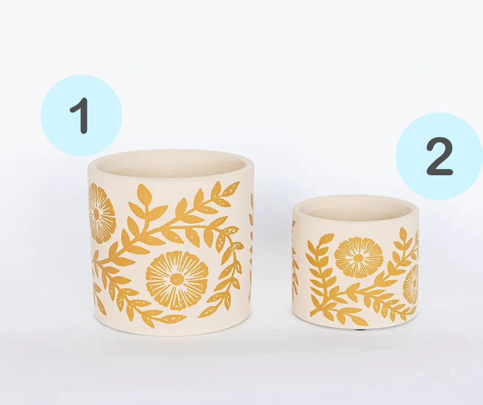 Small and large cement plant pots with a yellow floral and leaf pattern on a white background.