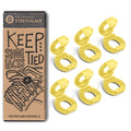 Set of bright yellow knot bow clips for securing shoelaces, shown next to packaging.