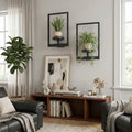 Set of two matte black industrial metal window-style wall shelves holding small decorative pots.