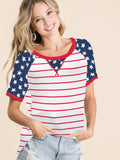 A woman wearing a relaxed fit, short-sleeve knit tee with red, white, and blue patriotic stripes and star print.