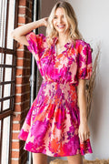 A colorful floral print mini dress with short sleeves and a smocked bodice