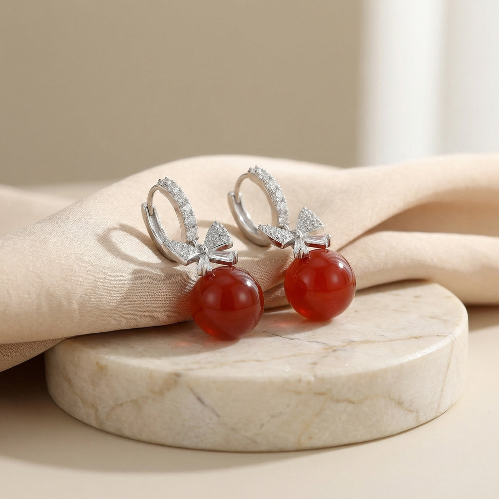 Vera Lux sterling silver drop earrings with red agate and crystal-encrusted bow design