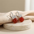 Vera Lux sterling silver drop earrings with red agate and crystal-encrusted bow design