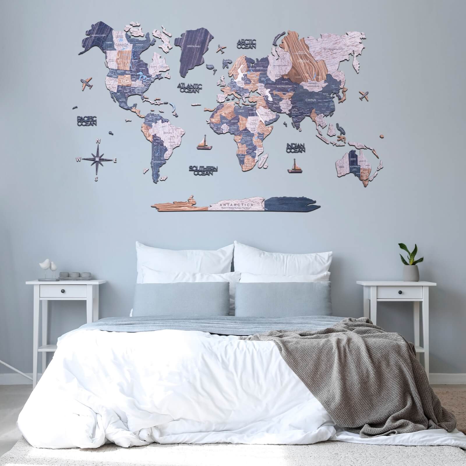 2D Wooden World Map from the Mystery collection featuring beige, dark-turquoise, gray, and white continents on a wall.