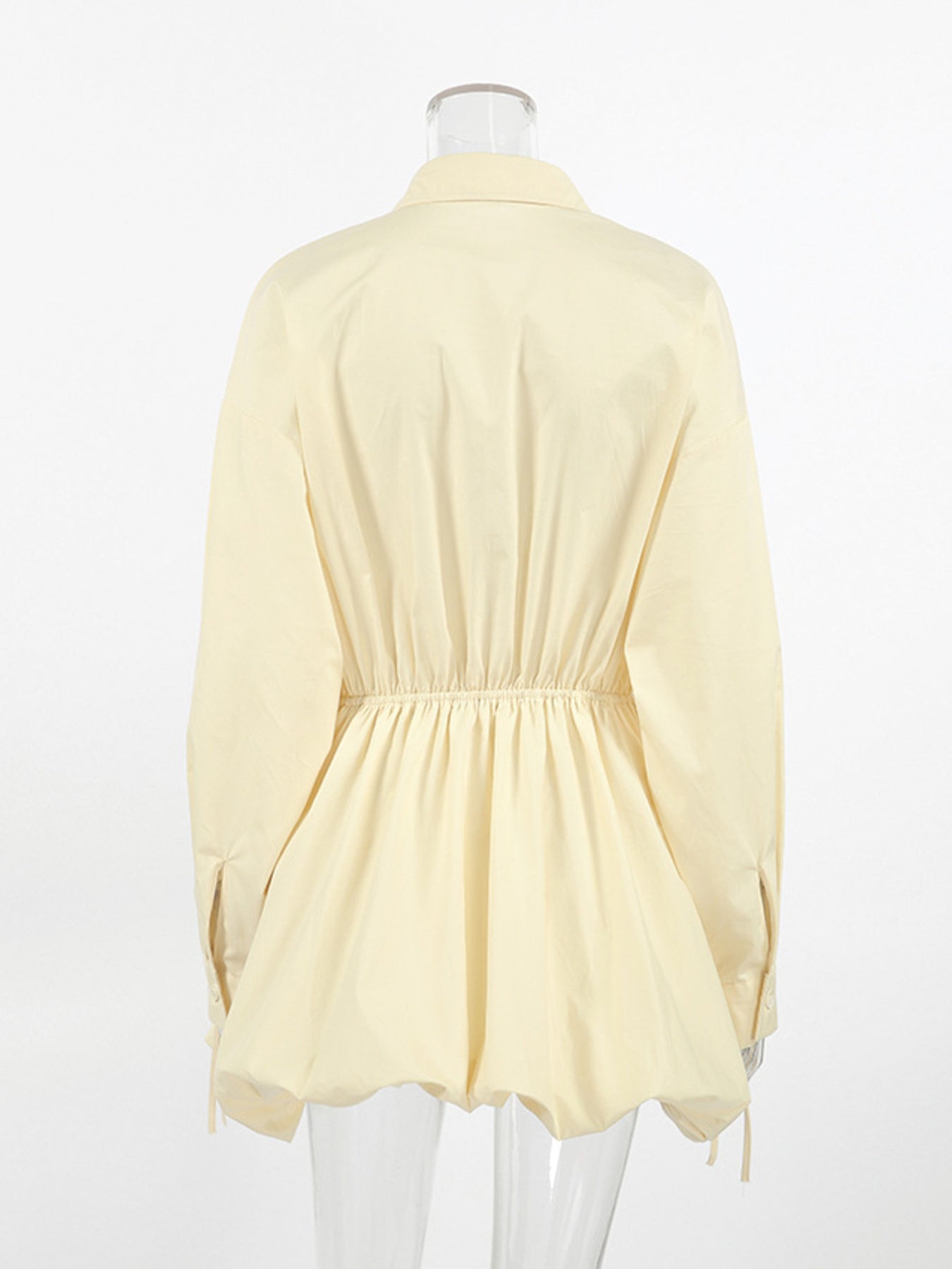 Light yellow blouse on a mannequin against a white background