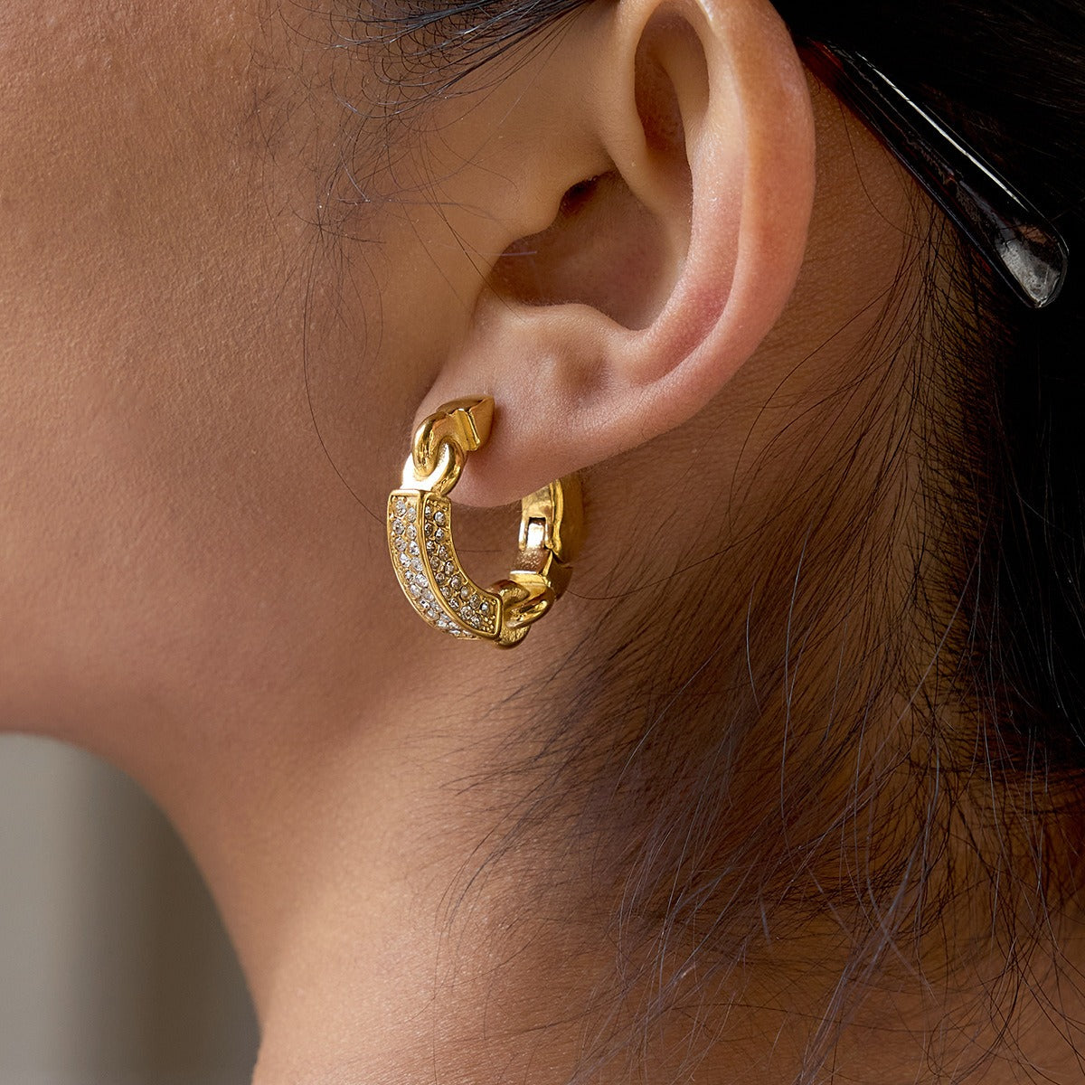 A pair of minimalist 18K gold lightweight hoop earrings in polished titanium steel.