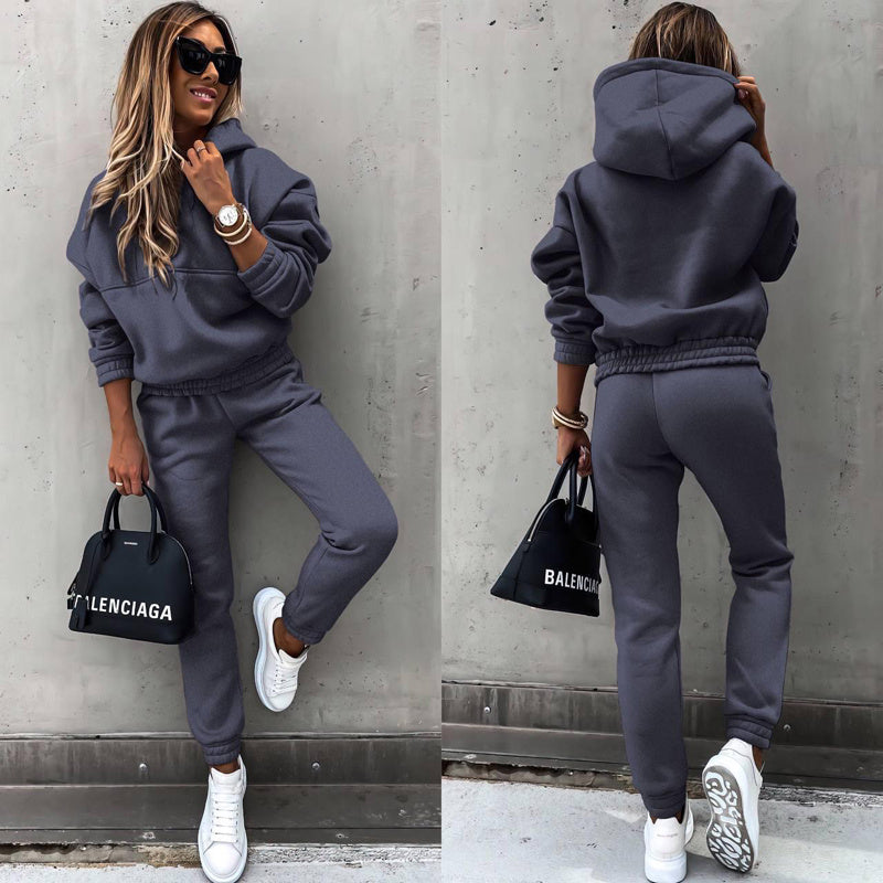 A woman wearing a solid color long-sleeve hoodie and slim-fit jogger pants matching set