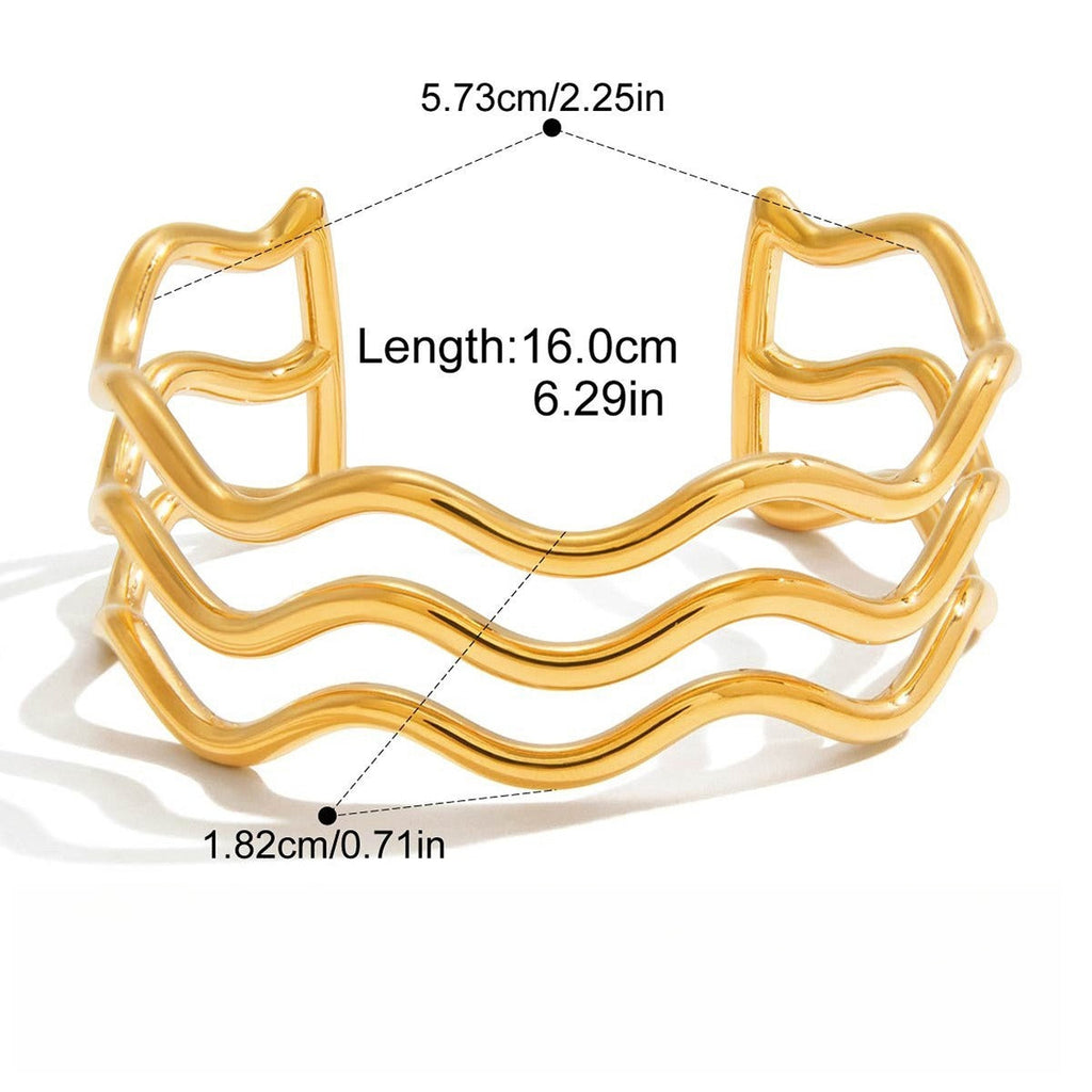 Vera Lux 18K gold wave bracelet featuring a sculptural, flowing design on a white background.