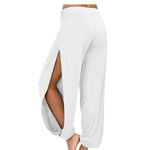 Model wearing solid color elastic waist beach pants with high side splits