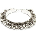 Close up of an oxidised silver bohemian bracelet with small ghungroo bells on a woman's wrist
