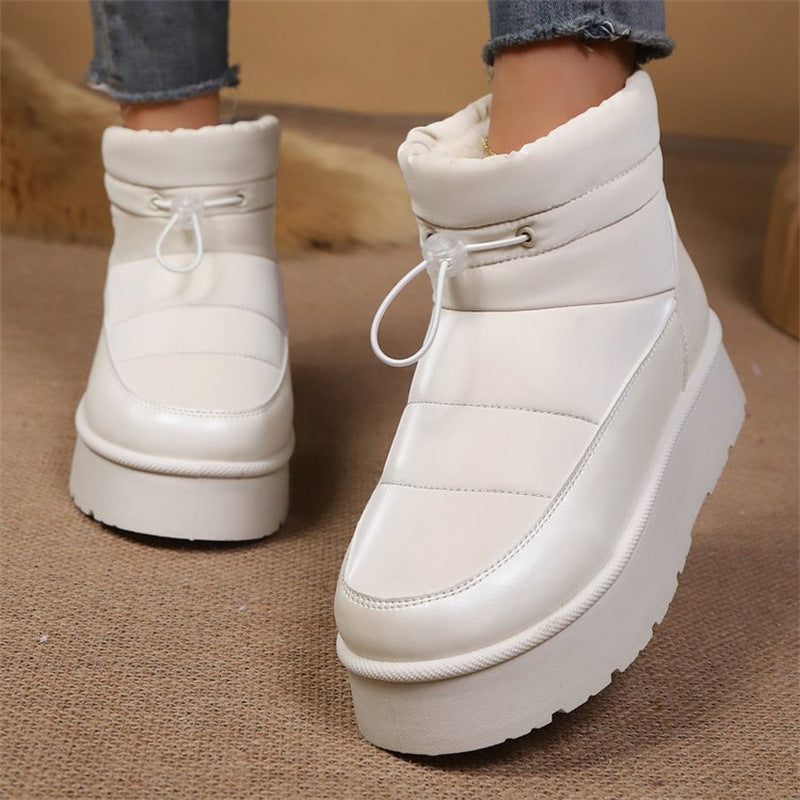 Close-up of stylish white women's short ankle boots with a fleece-lined interior and toggle closure.