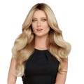 Woman wearing Down Time synthetic wig with glamorous cascading waves in a classic style.