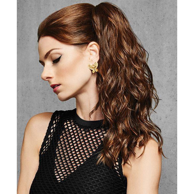 A woman wearing an 18-inch curly ponytail extension attached with a claw clip.